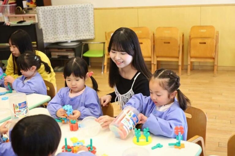 ブロックで作った作品を見せるこどもたちと、笑顔の辻村さん